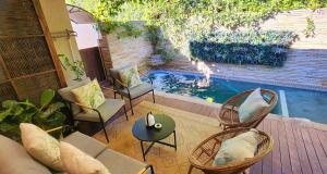 a patio with a pool with chairs and a table at Tuinvrede Guesthouse in Welgemoed