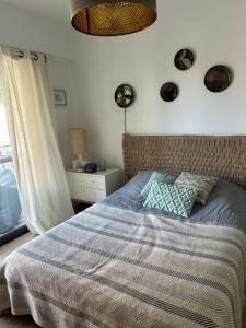 a bedroom with a bed with a blue comforter and a window at Les mimosas in Tosse +1 photo