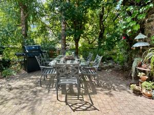 a table with chairs and a grill in a garden at Haus Auenland in Groß Felda +21 photos