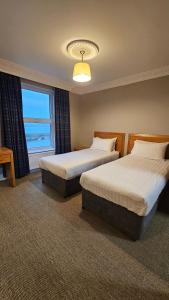 a hotel room with two beds and a window at The Beach Hotel in Mullaghmore +26 photos