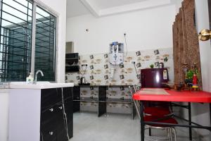 a kitchen with a red counter and a red table at Diya Homestay in Rāmpur Hāt
