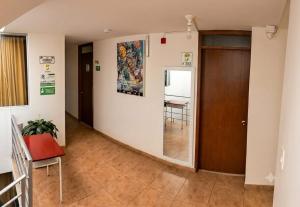 a hallway with a door and a chair and a table at Hotel Riviera Home in Pasto