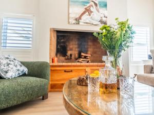 a living room with a coffee table and a fireplace at Luxe Pearl in Paternoster