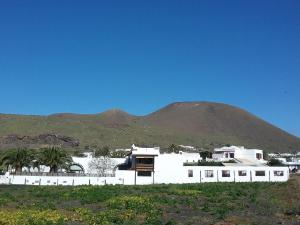 a white building with a mountain in the background at Casa Rural "La Molina" in Máguez +37 photos