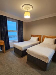 a hotel room with two beds and a window at The Beach Hotel in Mullaghmore
