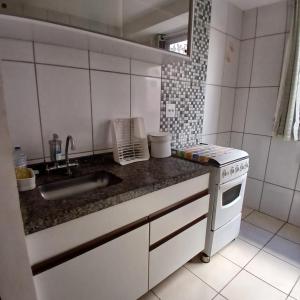 a small kitchen with a sink and a stove at Apartamento Aconchegante! in Uberaba +9 photos