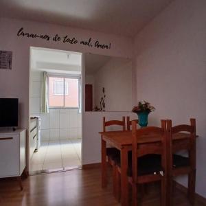a room with a table and chairs and a kitchen at Apartamento Aconchegante! in Uberaba