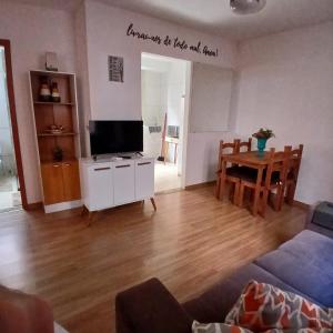 a living room with a television and a dining room table at Apartamento Aconchegante! in Uberaba
