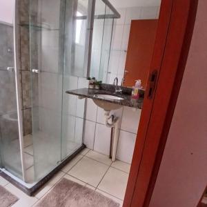 a bathroom with a sink and a shower at Apartamento Aconchegante! in Uberaba