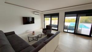 a living room with a couch and chairs and a tv at Villa Maja in Blagaj