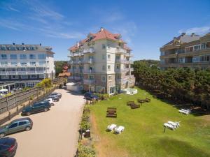 un gran edificio de apartamentos con césped delante en Costa Carilo Apart de Mar By HS en Cariló