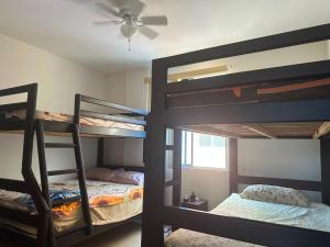 a room with three bunk beds and a ceiling fan at Departamento impecable en Tonsupa, Conjunto Vacacional Salaverry VI in Tonsupa +5 photos