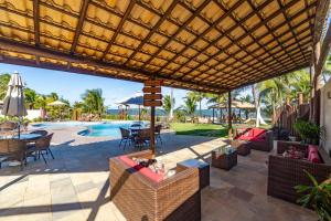 a patio with a table and chairs and a pool at Areias de Itacimirim in Itacimirim