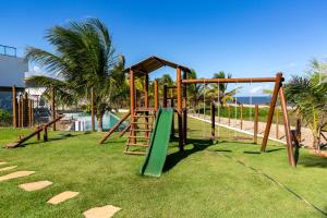 a playground with a green slide on the grass at Areias de Itacimirim in Itacimirim