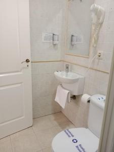 a small bathroom with a toilet and a sink at Hostal Alcarayón Pilas in Pilas