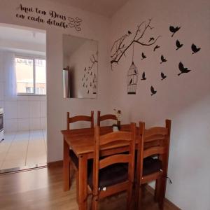 a dining room with a table and a bird cage on the wall at Apartamento Sossego! in Uberaba +10 photos