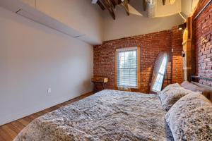 a bedroom with a large bed in a brick wall at Sweet Lancaster Apt. A in Lancaster