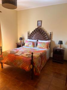 a bedroom with a large bed with a wooden headboard at Propriedade dos Seixos in Moledo