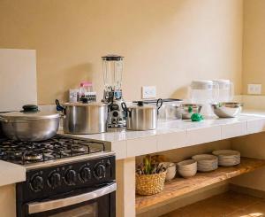 a kitchen counter with pots and pans on a stove at La Villa de Sofia in Santa Marta