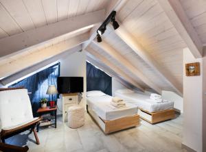a attic bedroom with two beds and a tv at Hippothoi Sea View Maisonette in Mesochórion +26 photos
