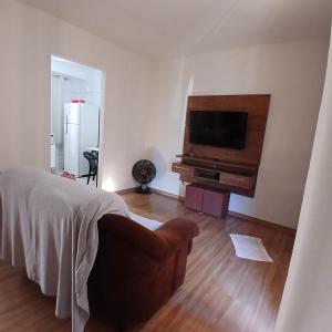 a living room with a bed and a television at Apartamento Serenidade! in Uberaba