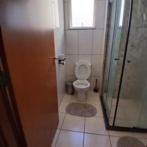 a bathroom with a toilet and a window and a shower at Apartamento Serenidade! in Uberaba +8 photos