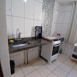 a kitchen with a sink and a stove at Apartamento Serenidade! in Uberaba