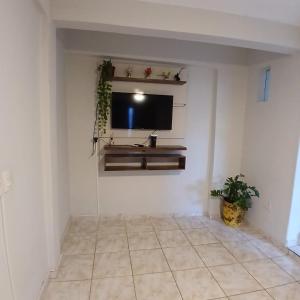 a living room with a flat screen tv on a wall at Sobrado Morada do Sol! in Uberaba