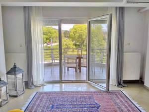 a room with a sliding glass door with a table on a balcony at Chloe Maxi Apt 110sqm in Kastoria