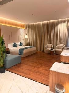 a bedroom with a bed and a couch and chairs at KH La Maison in Abha +50 photos