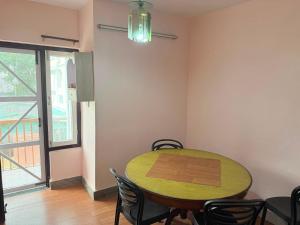 a room with a table and chairs and a window at Lux Apartment in Kathmandu