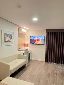 a hospital room with a couch and a tv on the wall at Seculo Hotel in Porto +39 photos