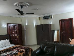 a bedroom with a bed and a ceiling fan at Royal Irenic Hotel in Madina