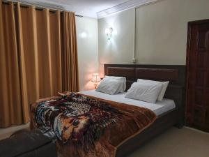 a bedroom with a bed and a couch in a room at Royal Irenic Hotel in Madina