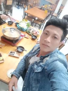 a young man sitting in front of a table at Dubai in Thuong Thon