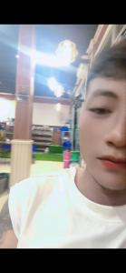 a young man wearing a white shirt in a room at Dubai in Thuong Thon