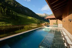 a swimming pool with a view of a mountain at Hotel Alpenhof in Tux