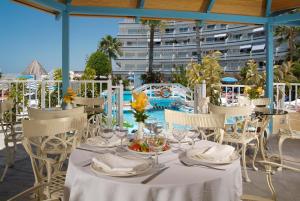 a table with white table cloths and chairs on a patio at HOVIMA Atlantis in Adeje