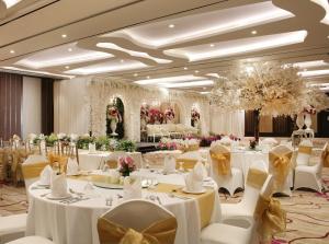 a banquet hall with white tables and chairs and flowers at Crowne Plaza Bandung by IHG in Bandung +216 photos