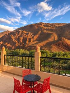 a table and chairs on a balcony with a mountain at Auberge Restaurant Zahra in Boumalne Dades