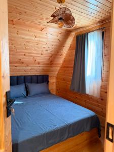 a bedroom with a bed in a wooden room at Ananta in Kobuleti