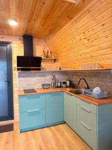 a kitchen with blue cabinets and a wooden ceiling at Ananta in Kobuleti +14 photos