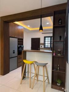 a kitchen with a counter and two stools in it at 2bedroom Harmony Apartment in Abuja