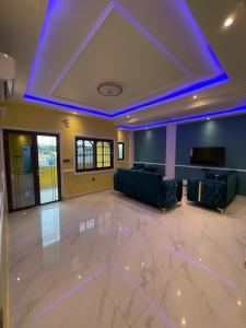 a large living room with a couch and a tv at Suite premium in Douala