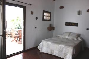 a bedroom with a bed and a door to a patio at Casa Rural "La Molina" in Máguez