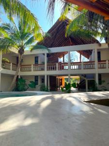 a building with palm trees in front of it at Casa del Viento by ÓOL Hotels in Holbox Island