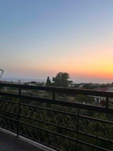 a fence with a sunset in the background at Theofania House Kanali in Kanali