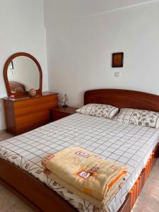 a bedroom with a bed with a dresser and a mirror at Theofania House Kanali in Kanali