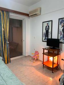 a bedroom with a bed and a desk with a television at Theofania House Kanali in Kanali