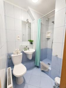 a blue and white bathroom with a toilet and a sink at Dom Wczasowy Larix in Rewal +70 photos